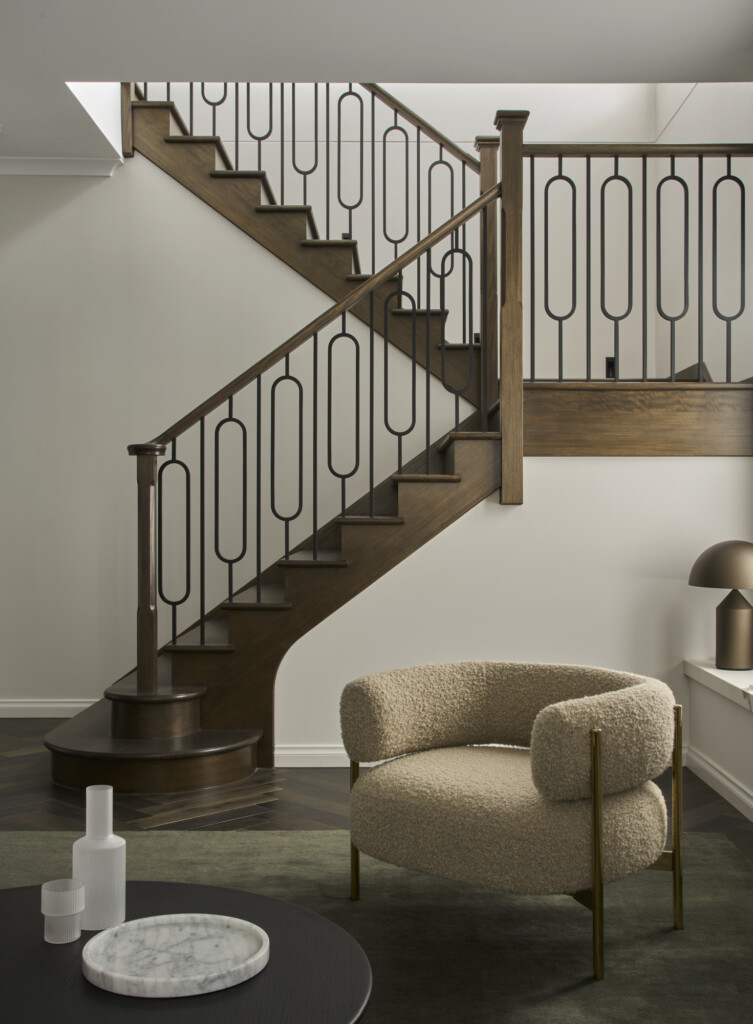 Boutique Homes Grange 60 - stairwell with timber balustrade and modern furnishings 