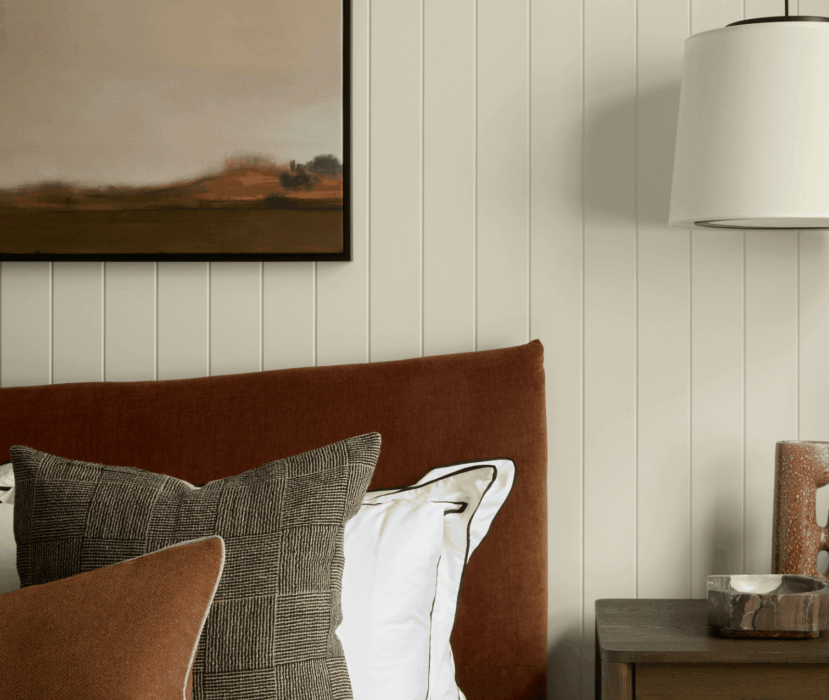 Oslo bedroom detail with bed, cushions and bedside table with lamp