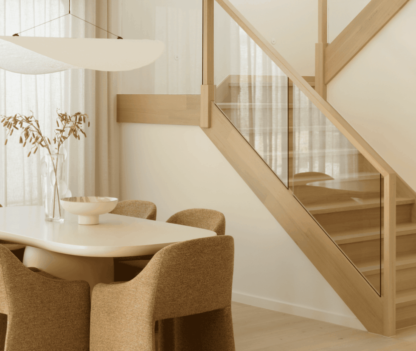 Montpellier 35 dining area with table, chairs and timber staircase with glass balustrade