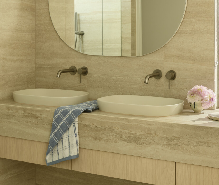 Modern bathroom with double vanity, stone benchtop and round mirror