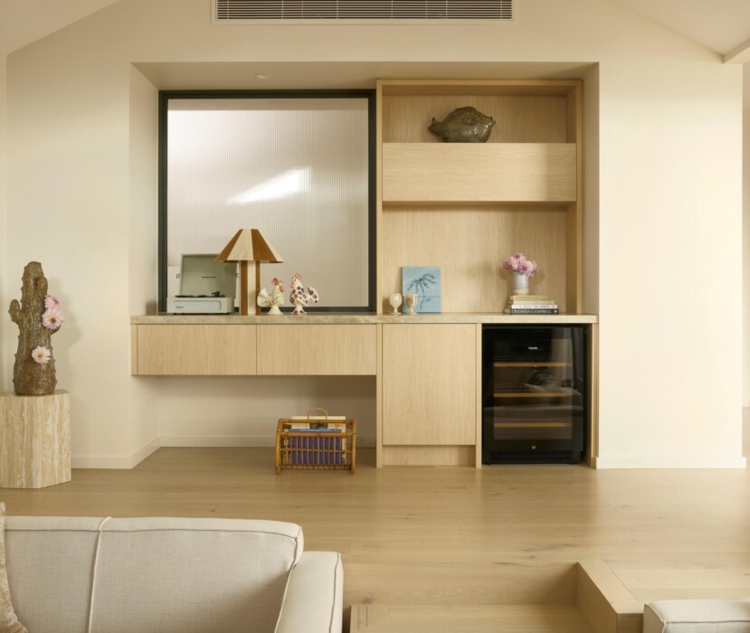 Boutique Homes cottage-style living room with custom timber cabinetry, built-in desk, open shelving, and integrated wine fridge in a light-filled modern home.