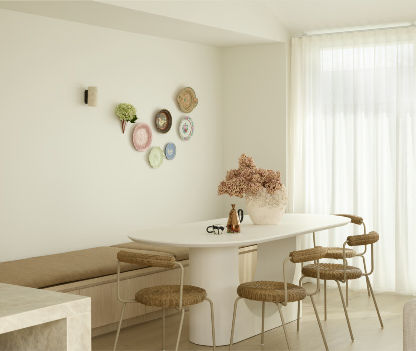 Modern dining area with neutral tones, built-in bench seating and natural light